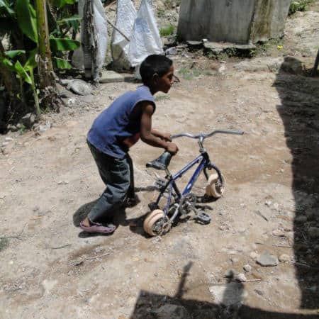 child living in poverty with old bike