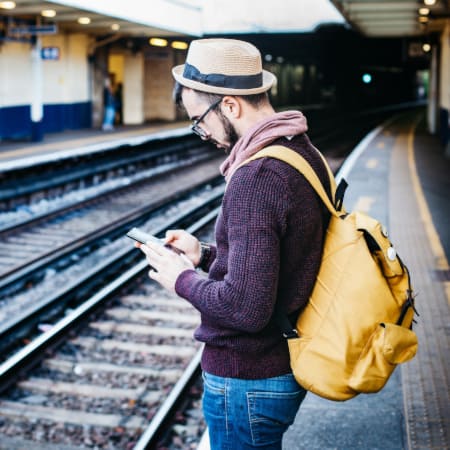 man texting at train station